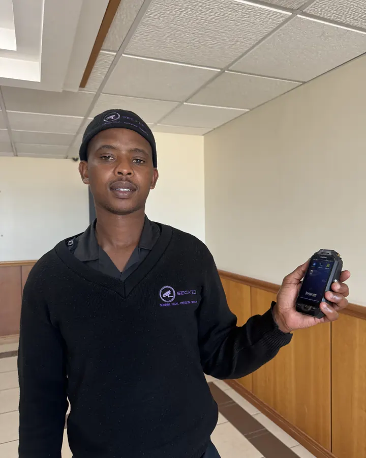 A SecaTeq security officer holding a handset in a building lobby.